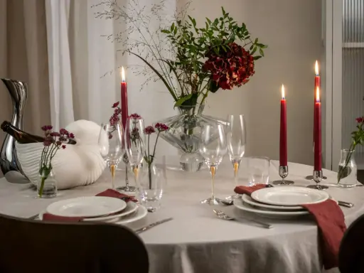En vacker dukning med röda ljus, blommor och glas. En perfekt inramning för en mysig middag.