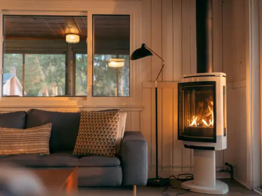 Un poêle à bois moderne chauffe une pièce cosy. Respectez la distance à respecter autour d'un poêle à bois pour une sécurité optimale.