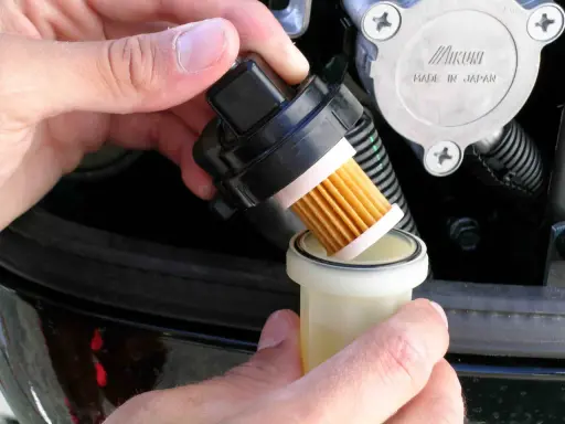 Maintenant, je procède au changement du filtre à gasoil. Le nouveau filtre est prêt à être installé.