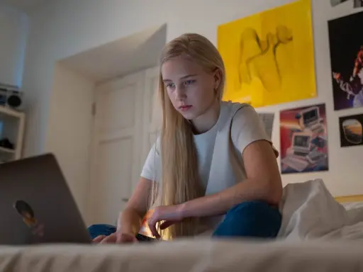 Dziewczyna szuka w internecie informacji, gdzie można pracować w wieku 16 lat.