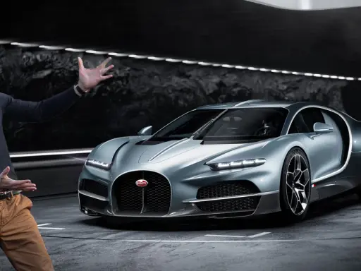 Mężczyzna prezentuje srebrnego Bugatti. Zastanawiasz się nad bugatti cena?