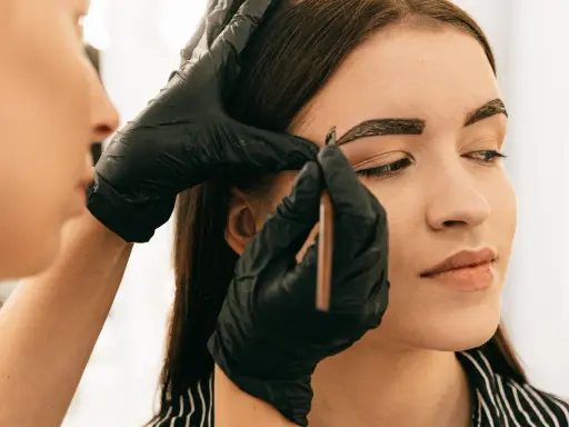 Application de henné sur les sourcils pour un regard intense.