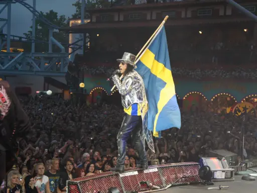 Alice Cooper i Sverige, med svensk flagga och en stor publik som filmar.