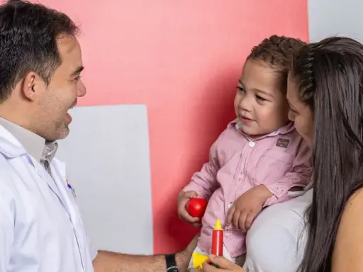 Médico habla con madre y niño, buscando entender los problemas de concentración del pequeño.