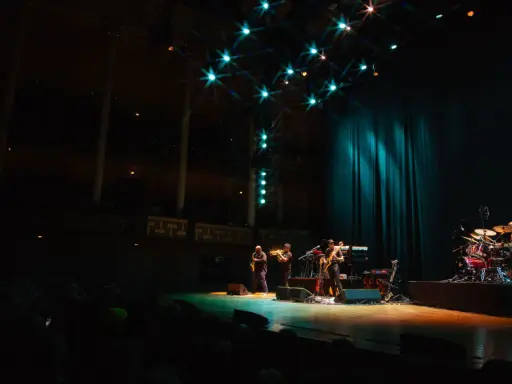 En jazzgrupp spelar på en scen under Stockholm Jazz Festival. Ljusen lyser upp scenen och publiken sitter i mörkret.