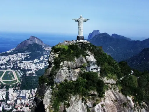 Majestatyczny pomnik Rio de Janeiro Jezus góruje nad miastem i oceanem, otoczony bujną zielenią i skalistymi szczytami.