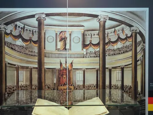 Blick in die Paulskirche, wo 1849 die Paulskirchenverfassung verabschiedet wurde. Viele Menschen verfolgen die Debatten.