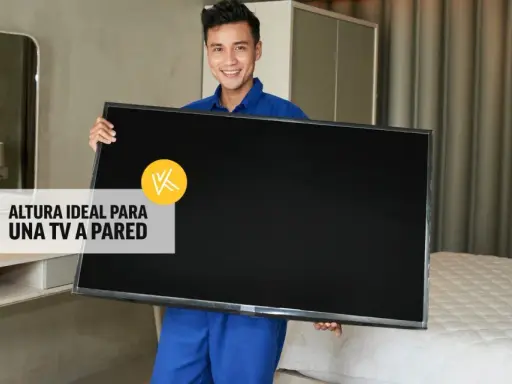 Hombre sonriente sostiene un televisor, listo para instalarlo. La altura ideal para un mueble de TV suspendido es clave.