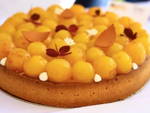 Tarte aux abricots, une spécialité de Metz, garnie de fruits brillants et de décorations délicates.
