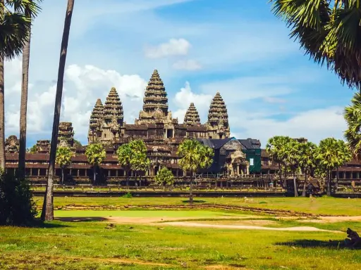 Angkor Wat, Cambodia, a majestic temple complex, bathed in sunlight. A gay couple enjoys the view, embracing the beauty of this historic site.