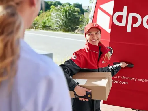 Kurierka DPD z paczką, obok czerwonego vana. Na paczce widoczny numer listu przewozowego przykład.