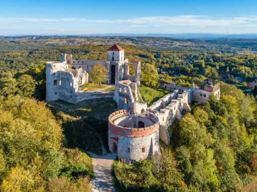 Ruiny zamku w Krzeszowicach, majestatycznie wznoszące się na wzgórzu, otoczone jesiennym lasem.