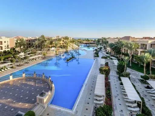 Luksusowy resort Jaz Aquamarine z basenami o turkusowej wodzie, palmami i budynkami hotelowymi.