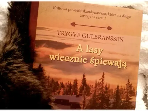 Okładka książki "A lasy wiecznie śpiewają" Trygve Gulbranssena, otoczona miękkim futrem.