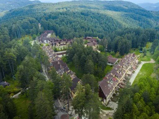 Villaggio Mancuso immerso nel verde, con case a schiera e palazzine circondate da fitti boschi di conifere.