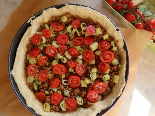 En tacopaj redo att bakas, fylld med köttfärs, tomater och paprika. Ett perfekt tacopaj recept för helgen!