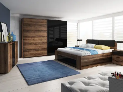 Dormitorio con muebles oscuros de madera y cristal negro. Pared azul oscuro, alfombra azul y cama con ropa de cama blanca y azul.