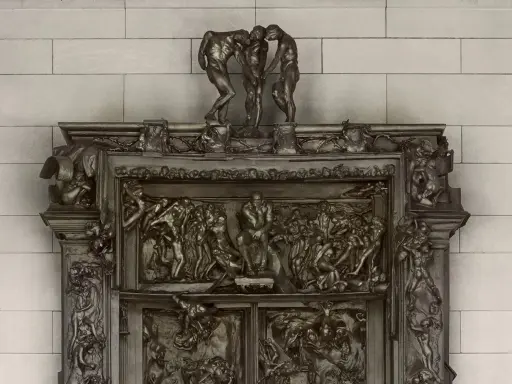 Detaljerad bronsrelief av helvetets portar, med figurer i dramatiska poser.