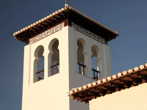 Weiße Moschee in Granada mit arabischer Kalligrafie und maurischen Bögen.