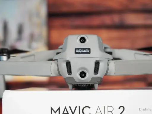 Graue Drohne Mavic Air 2 mit Kameras und Propellern. Auf dem Gehäuse ist ein Aufkleber mit der Kennung zur drohne registrieren.