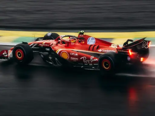 Czerwony bolid F1 2018 z numerem 55 na torze, w deszczu.