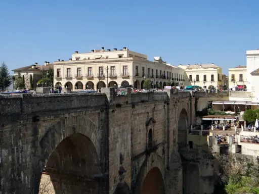 Ein perfekter tagesausflug seville: die Puente Nuevo in Ronda, mit Häusern, die sich an die Felsen klammern.