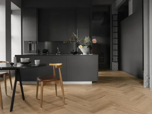 Cuisine moderne avec îlot central, chaises en bois et table en marbre. Le parquet en chevrons, bien que beau, est une mauvaise idée pour une cuisine.