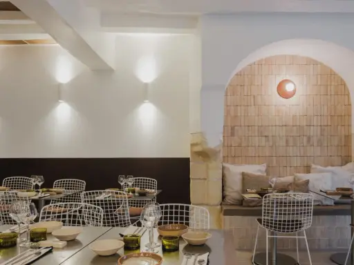Ambiance chaleureuse dans ce qui semble être le meilleur resto à Tours. Tables dressées, chaises design et mur en briques apparentes créent une atmosphère accueillante.