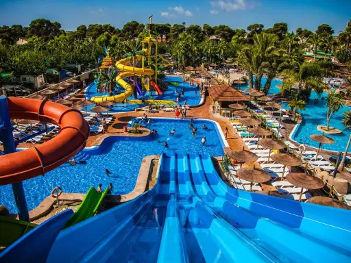 Parque acuático con toboganes, piscinas y palmeras. Ideal para hoteles temáticos para niños.
