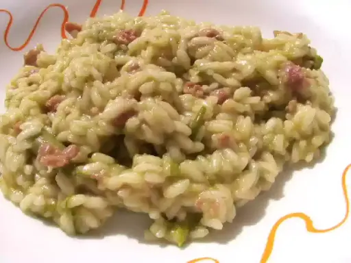 Un cremoso risotto asparagi e salsiccia, un piatto ricco di sapore e colore, pronto per essere gustato.