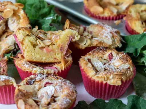 Muffins med rabarber och mandel, pudrade med florsocker. Perfekt att baka med rabarber nu!