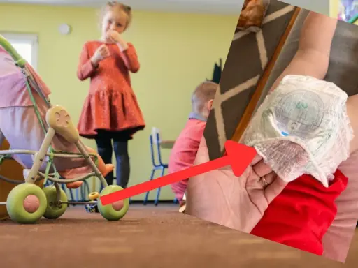 Dziecko w pampersie, obok wózek dla lalek i inne dzieci bawiące się w pokoju.