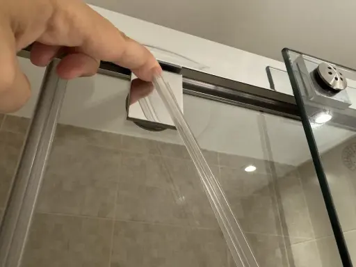 Mano insertando una goma nueva para cambiar gomas mampara ducha.