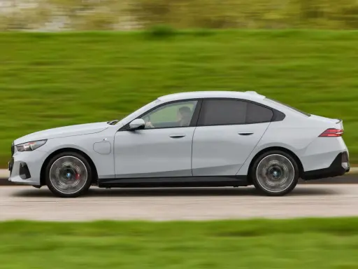 Ein grauer BMW 550e fährt auf einer Straße, die Landschaft verschwimmt im Hintergrund.