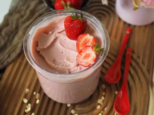 Cremiges Kefir Eis mit frischen Erdbeeren garniert, bereit zum Genießen.