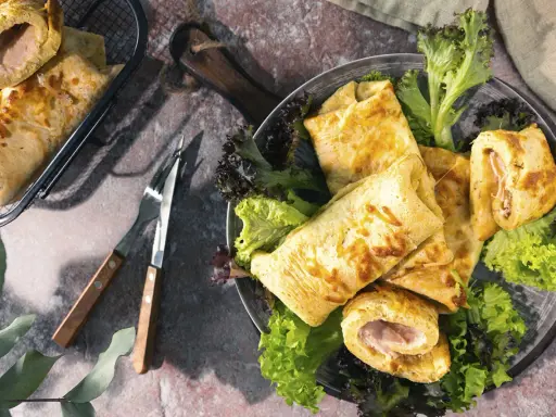 Herzhafte Pfannkuchen gefüllt mit Schinken und Käse, serviert mit frischem Salat. Ein Genuss für jeden Gaumen!