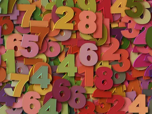 Kolorowe cyfry tworzą gęsty wzór. Wśród nich wyróżnia się liczba 2, symbolizująca rok numerologiczny 2, zachęcając do harmonii i współpracy.