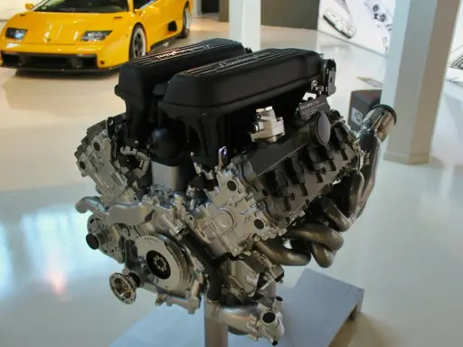 Silnik Lamborghini V10. Zapchany smok olejowy objawy mogą prowadzić do uszkodzenia. W tle żółty sportowy samochód.