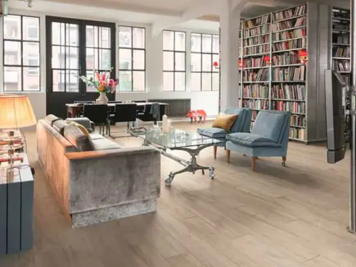 Estanterías llenas de libros ofrecen fantásticas ideas para colocar libros en un salón moderno con sofás, mesa de centro y comedor.