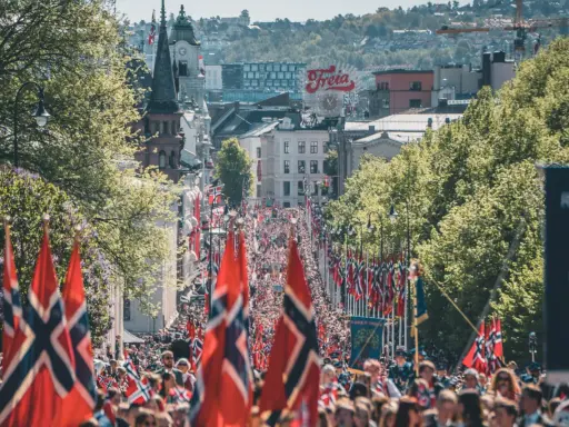 Tłum ludzi na ulicy w Oslo, z norweskimi flagami. Czy Norwegia jest w NATO? Tak, jest członkiem od 1949 roku.