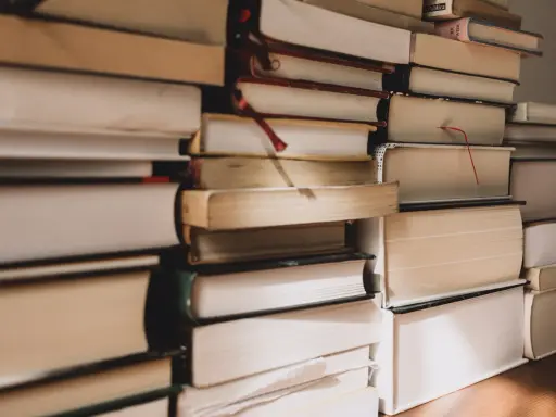 Pile di libri, alcuni con segnalibri rossi, pronti per essere letti. Ecco i miei ultimi libri consigliati.