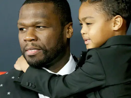 50 Cent z synem, chłopiec w czarnym garniturze przytula się do ojca.
