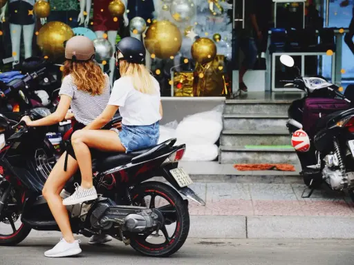 Dos chicas con cascos en una moto, listas para sacar carnet moto y disfrutar de la libertad.