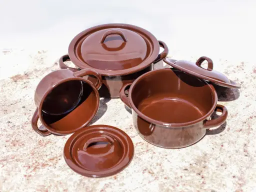 Conjunto de cazuelas de barro esmaltada en marrón. Listas para curar y preparar deliciosos guisos.