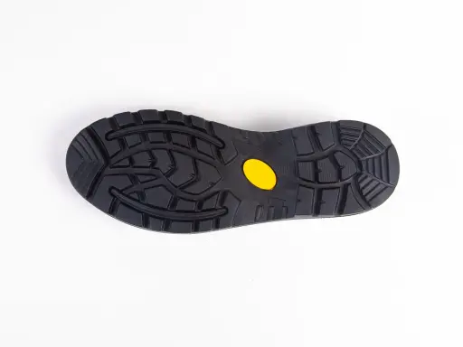 Czarna podeszwa buta z żółtym logo Vibram, gotowa do wymiany w butach, zapewniająca przyczepność.