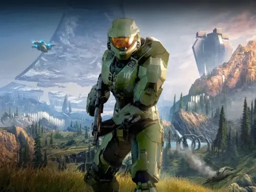 Master Chief w zbroi z Halo Infinite stoi na tle górskiego krajobrazu z pierścieniem Halo i pojazdem UNSC.