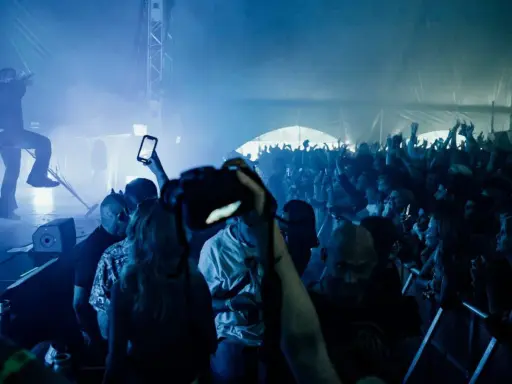 Publik jublar på en konsert i Göteborg. En artist uppträder på scenen i blått ljus och rök. Många i publiken filmar med sina mobiler.