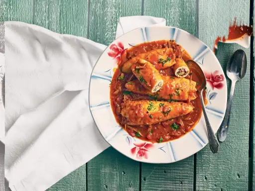 Assiette de calamars farcis à la sauce tomate, une recette encornet tomate savoureuse, garnie de persil frais.