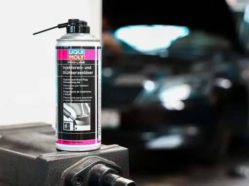 Puszka preparatu do czyszczenia wtryskiwaczy Liqui Moly na tle rozmazanego silnika.