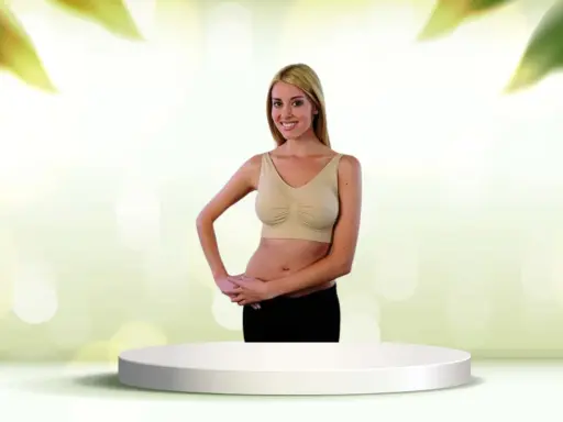 Donna sorridente con tette e reggiseno beige, in piedi su un piedistallo bianco.